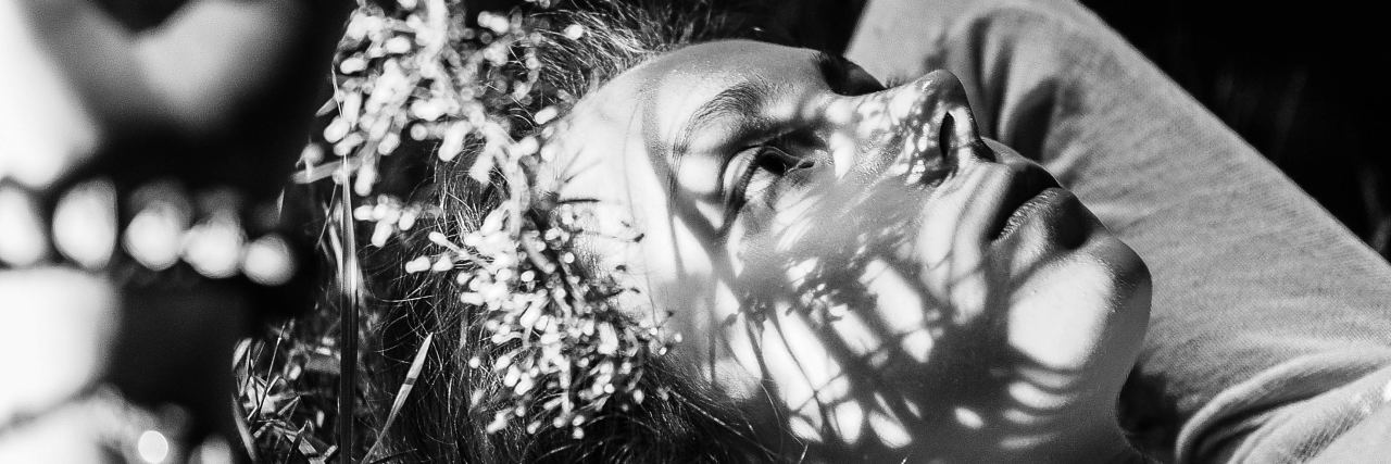 Channeling Anger at Chronic Pain Into Strength black and white photo of woman lying back looking angry