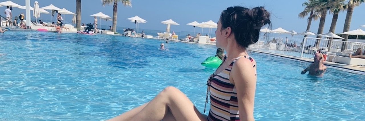 woman in bathing suit posing by a pool