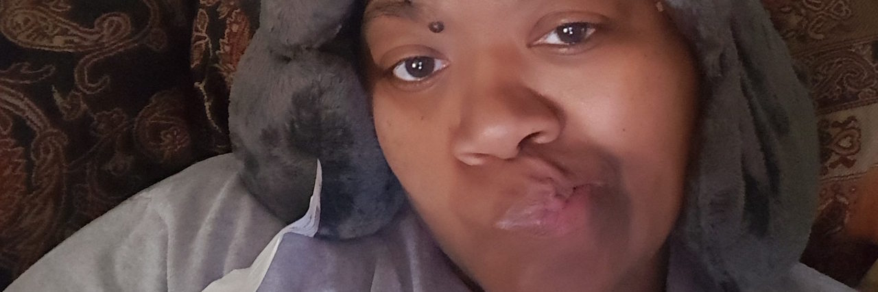 Responding to Strangers' Judgments About Chronic Illness Jae on the couch in comfy clothes.
