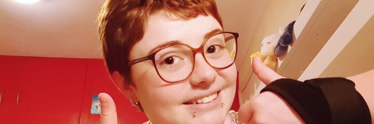 The Sentence My Doctor Said That Changed My Whole Outlook a girl is smiling giving the thumbs up sign.