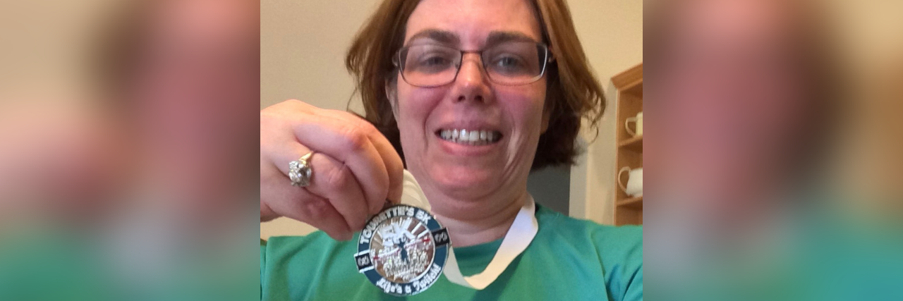 Finding Support When Raising a Child With Tourette Syndrome Minda holding her 5K medal.