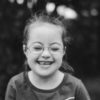 Black and white image of girl with Down syndrome smiling