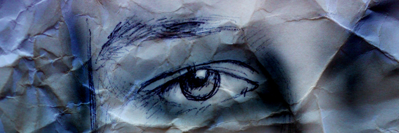 Drawing of a woman's face on crumpled paper.