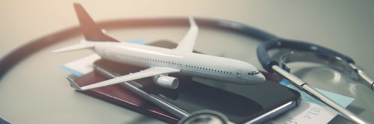 Travel insurance concept, model plane, stethoscope and passport.