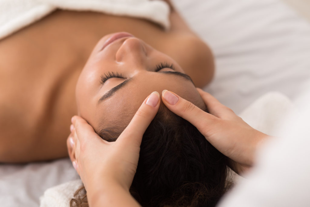 woman receiving a massage and facial