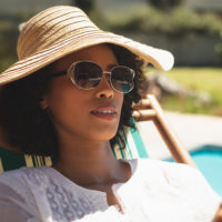 African American woman with hat and sunglasses on a sunny day