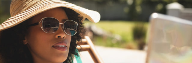 African American woman with hat and sunglasses on a sunny day