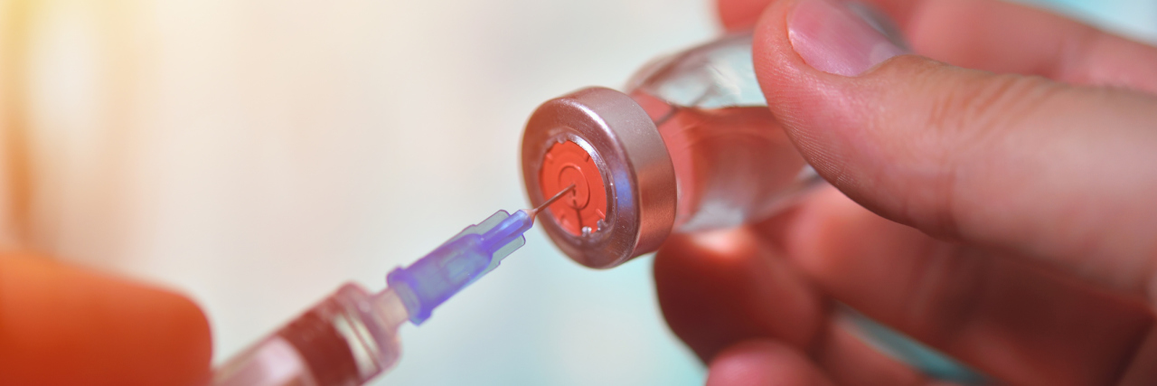 Parents Sue School for Not Allowing Their Son to Bring His Own Insulin Closeup of vaccine bottle with syringe and needle for immunization on vintage medical background, medicine and drug concept