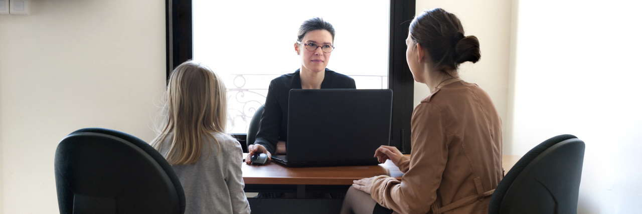 Why Autistic Children Should Attend Their Own IEP Meetings Mother and daughter meeting with teacher.