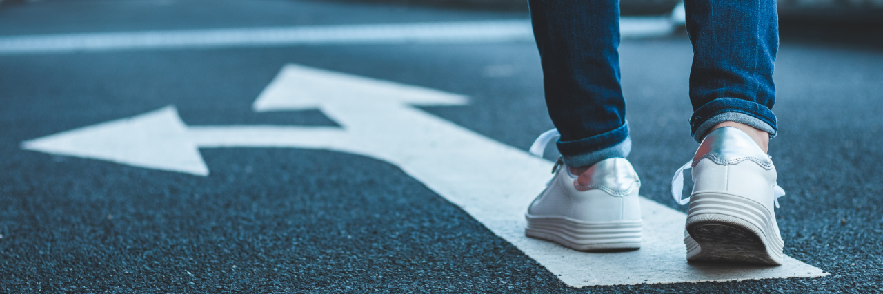Divorce Is a Liminal Space in Life woman walking approaching painted arrows on street
