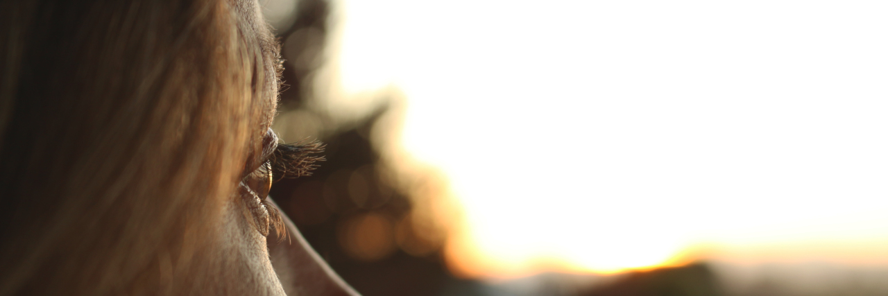 Deciding to Have Kids as the Genetic Carrier of a Rare Disease close-up of woman looking towards sun and trees