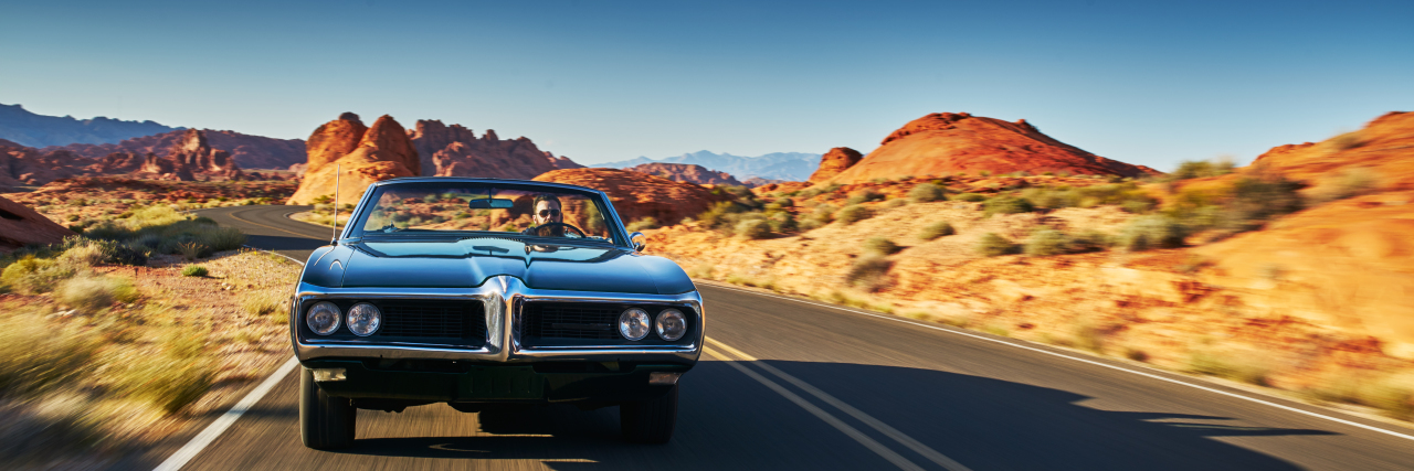 How My Crohn's Disease Is Like a Road Trip Man driving vintage car through desert in Nevada.