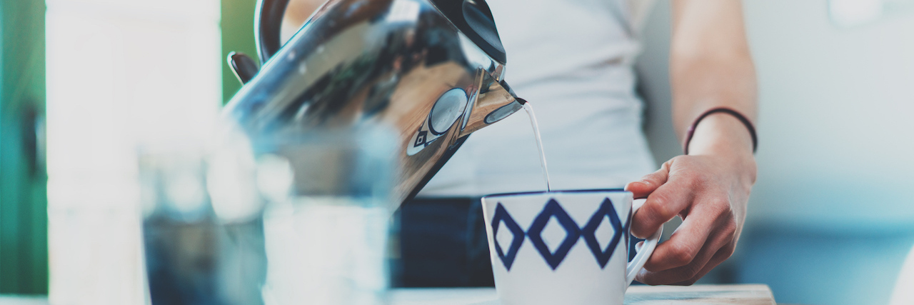 A woman pouring hot water in cup