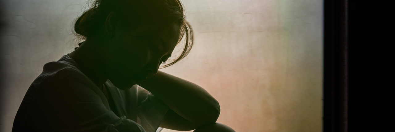 Everyone Grieves Differently in Grief Counseling Vintage filtered on silhouette of depressed girl sitting on the window