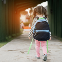Kid girl pupil walking back to home after learning study school alone with schoolbag,preschool and kindergarten education concept.