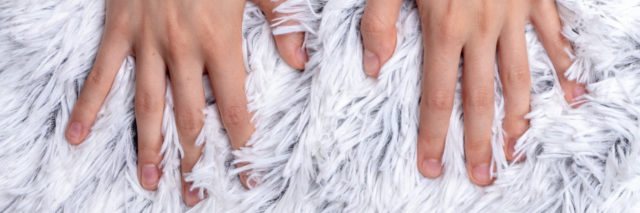 Pair of hands on a soft furry blanket.
