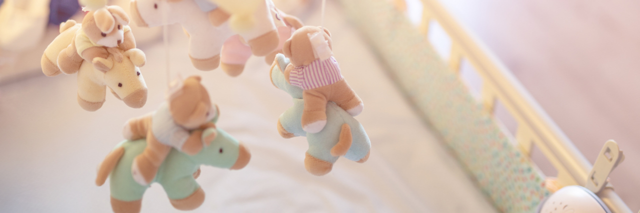 I Will Forever Love and Grieve My Stillborn Baby a close-up of a baby mobile hanging in a crib.