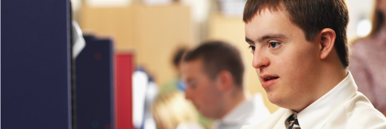 Why Can Workers With Disabilities Be Paid Less Than Minimum Wage? man with down syndrome working in an office
