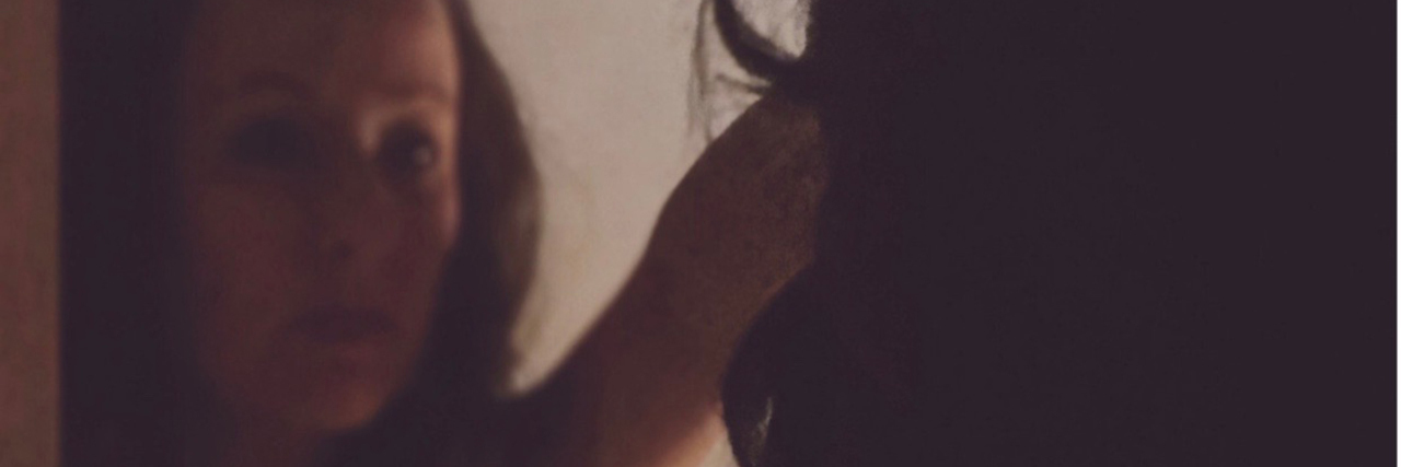 Grieving Your Lost Self After a Traumatic Brain Injury Sara looking in the mirror.