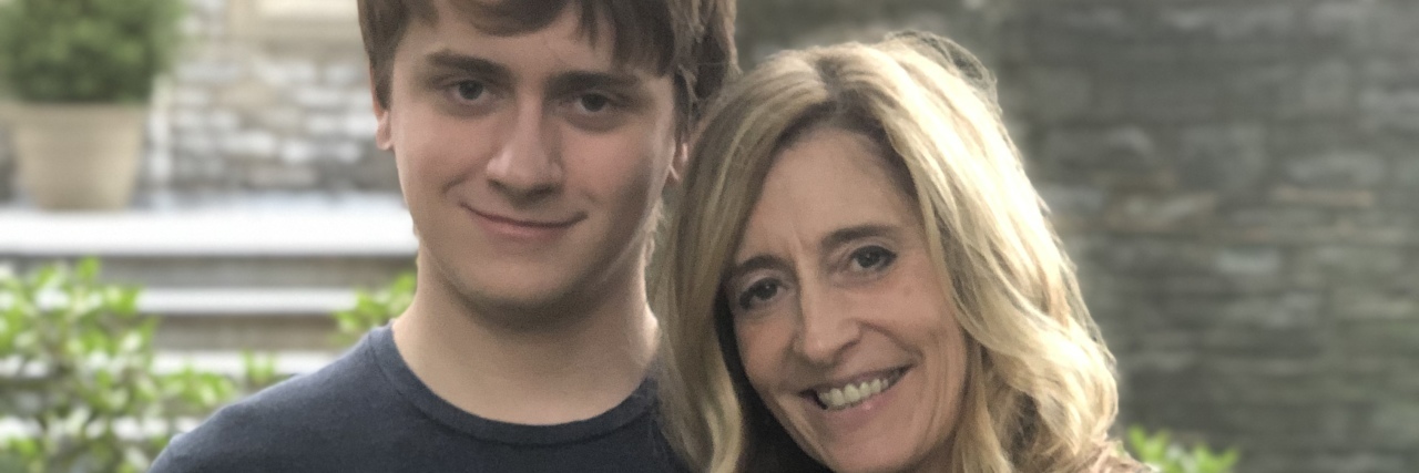 When My Autistic Teen Invited Me to the Movies Son and mother hugging smiling at camera