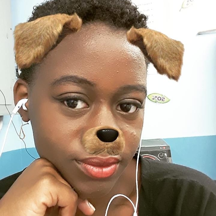 woman using "dog face" snapchat filter. Resting head on hand with short hair