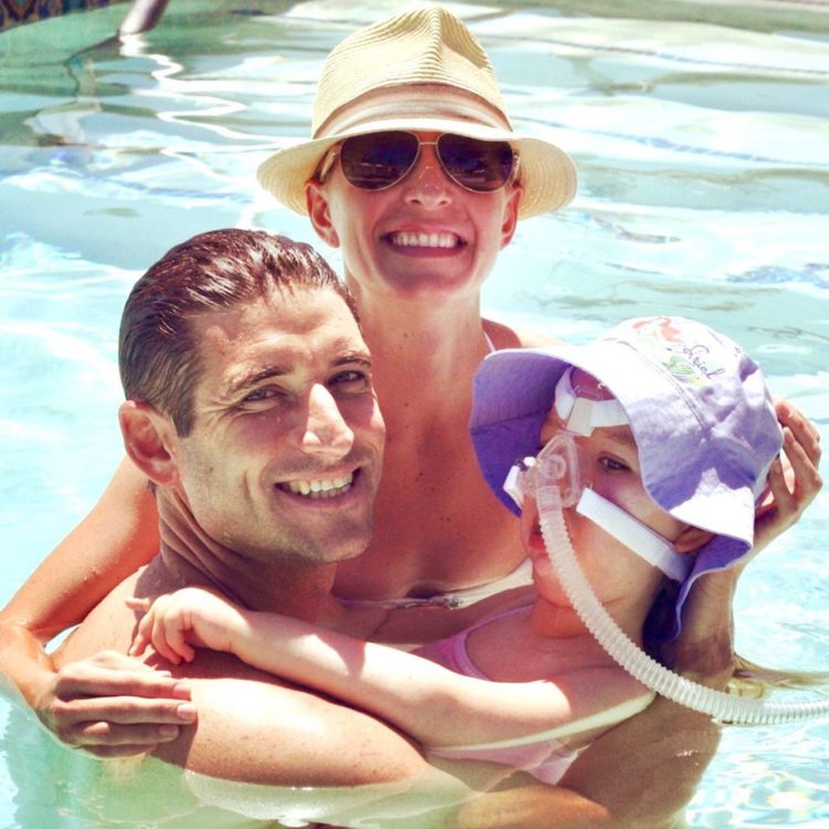 Mother and father swimming with disabled daughter