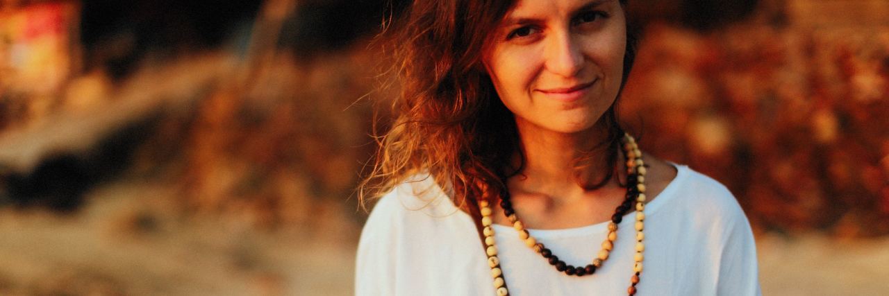 Bravery Beads for Adults With Mental and Chronic Illness photo of woman standing in sunset light looking at camera with long beaded necklace around her neck