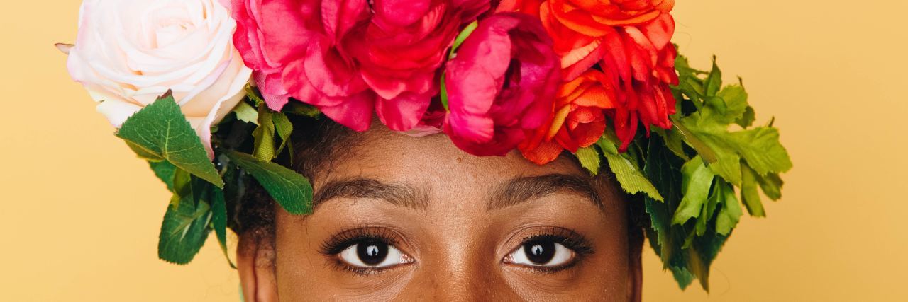 Color Alternative to Spoon Theory for Explaining Chronic Illness photo of woman wearing flower crown against yellow background looking into camera