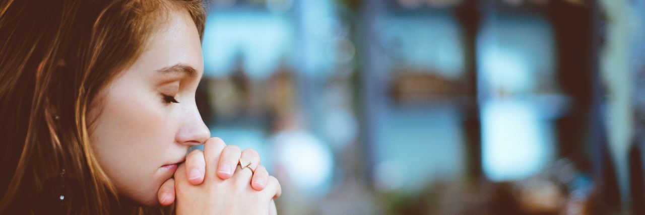 Experiencing Anxiety and Trauma Because of Chronic Illness woman with her head resting on her hands, folded