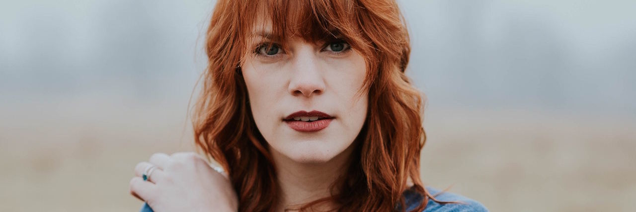 How My Supportive Boyfriend Helps Me Heal From Trauma A red-haired woman with a tattoo on her wrist