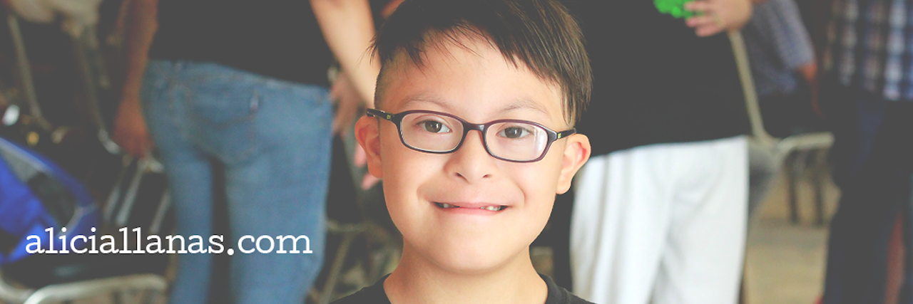 Boy with Down syndrome smiling at camera