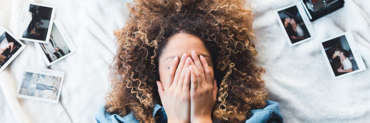 Anxiety Makes Time Management Difficult photo of woman lying on bed with hands covering face and polaroid photos lying around her