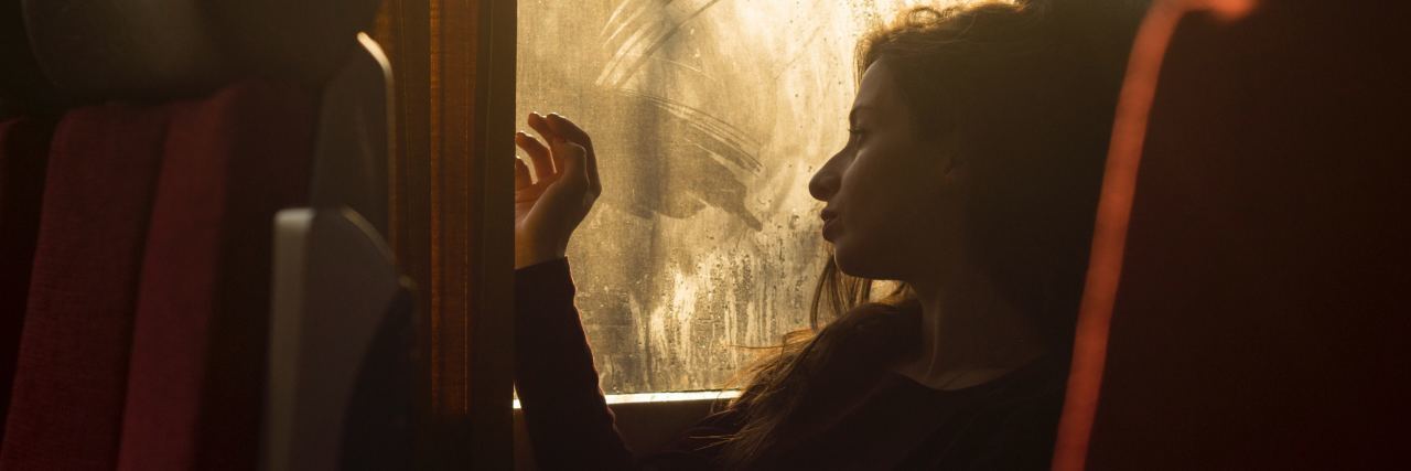 I’m Sick of Being Sick With Depression and PTSD photo of bored tired looking woman on train or bus looking out of dirty window