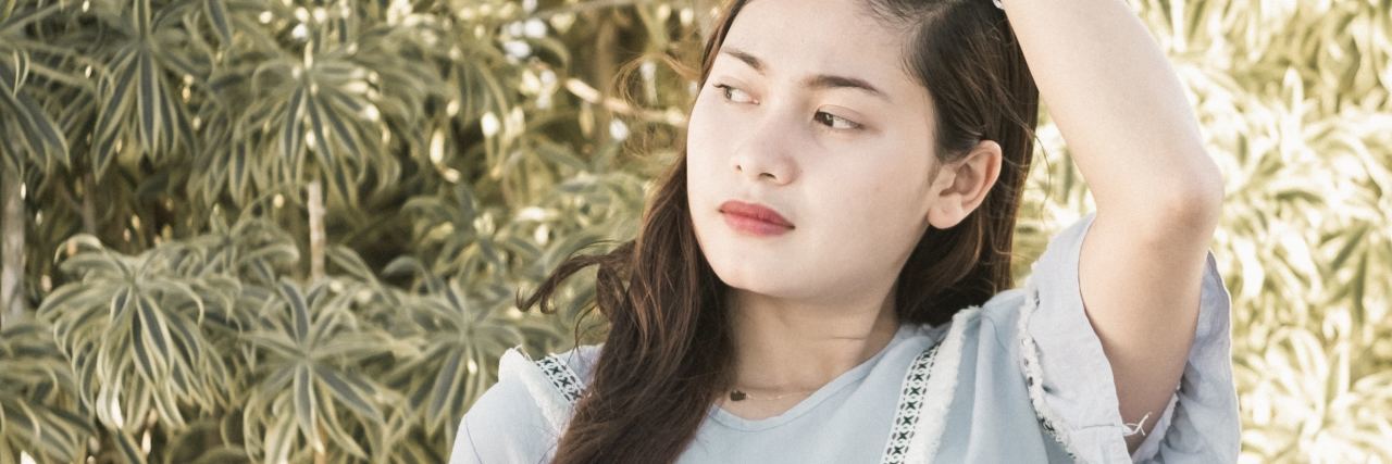 What It's Like to Have Bipolar II Disorder photo of young woman standing on balcony wearing blue dress with her hand in her hair