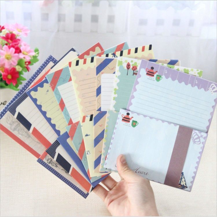 Image of a person holding up 7 different types of stationary and envelopes