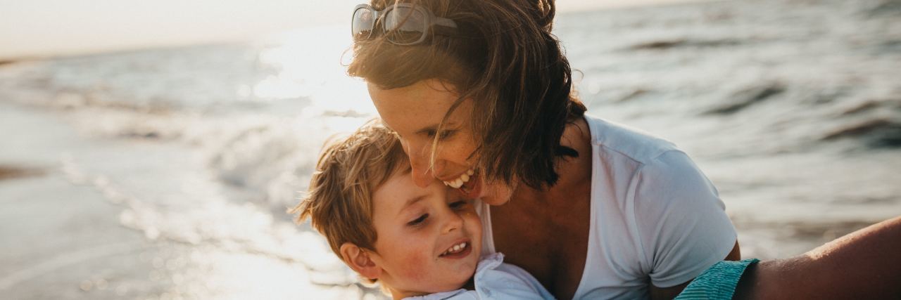 Why I'm Not a 'Hero' For Being a Mom of Kids With Diabetes woman holding young son at beach