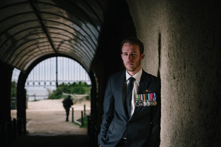 the author standing in a shadowy corridor wearing his military uniform