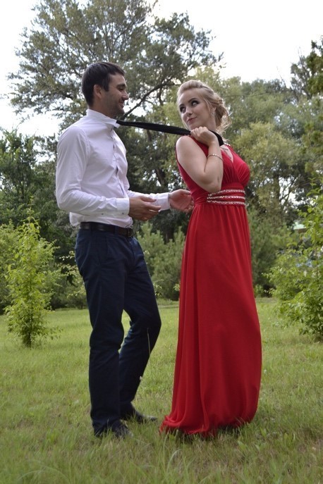 Male and female party guests. She is playfully pulling on his tie.