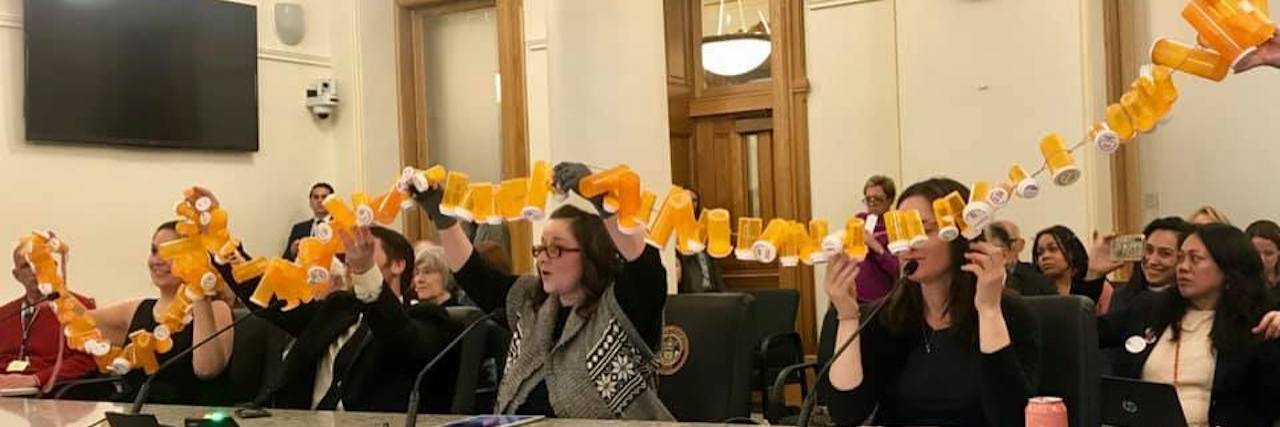 5 Tips for Surviving the Medical Industrial Complex women seated at table holding up pill bottles connected with string