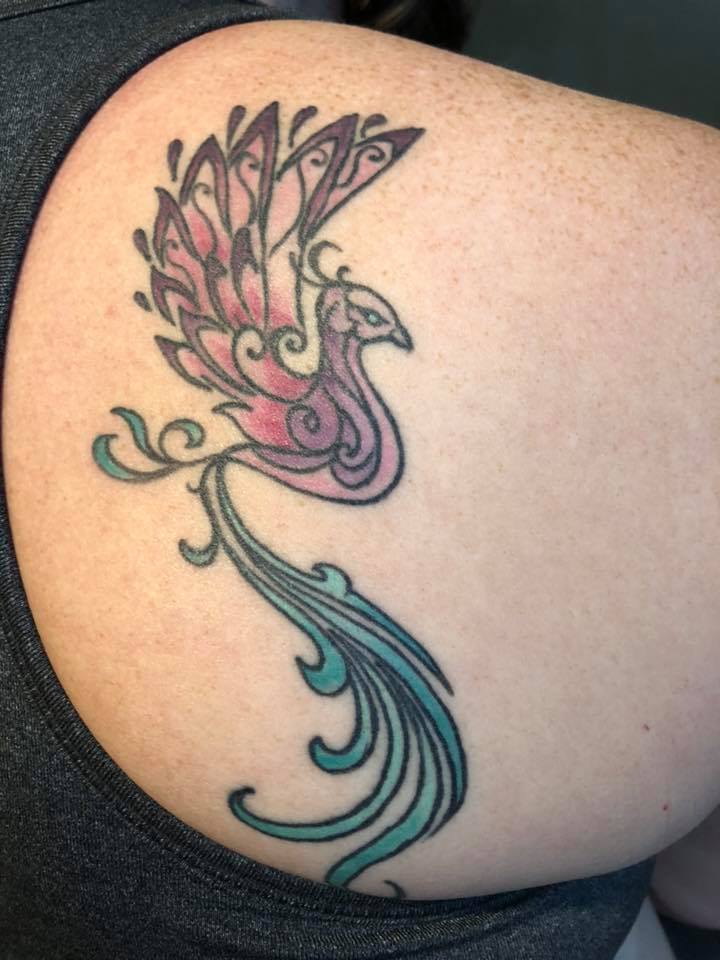 tattoo of a phoenix on a woman's shoulder