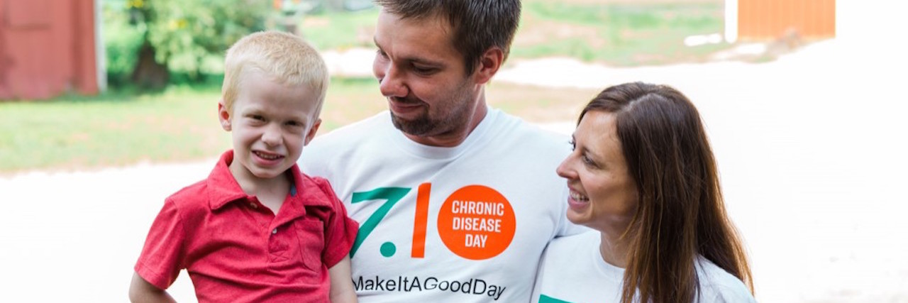 A man and a woman holding their child, wearing Chronic Disease Day shirts