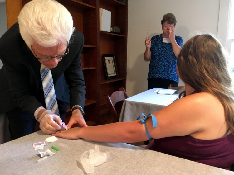 Steve Wickham, who is a nurse, draws blood at the midpoint of his and his wife Karen's six-week diabetes seminar. The hemoglobin A1c levels measured by the lab test help patients monitor whether the diet and exercise changes they're engaged in are making a difference in their blood sugar levels.