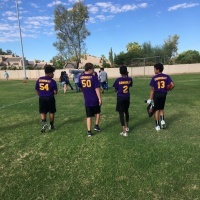 Backs of 4 students wearing football jerseys