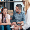 photo of parents with daughter in therapy session sitting on sofa in front of female therapist