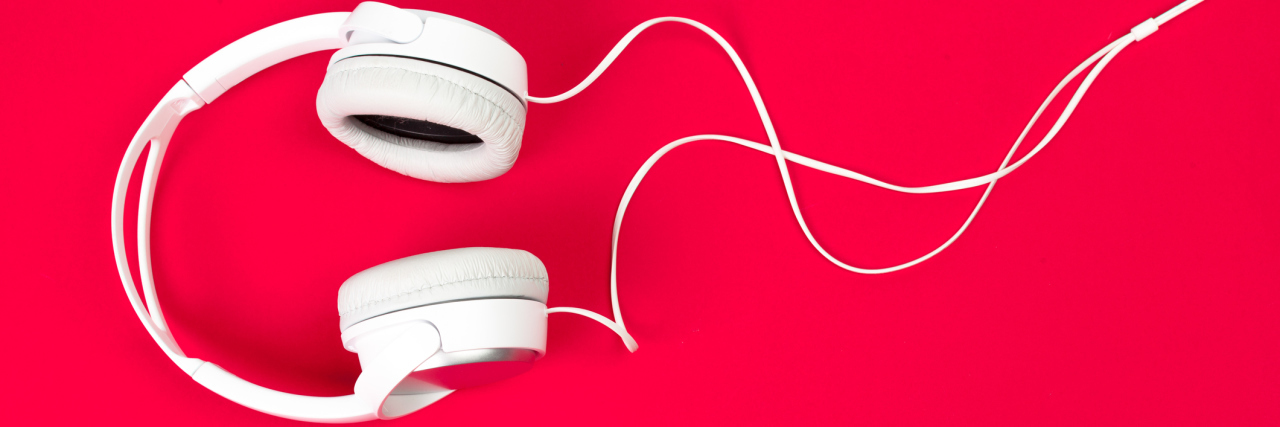 white headphones on red surface