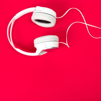 white headphones on red surface