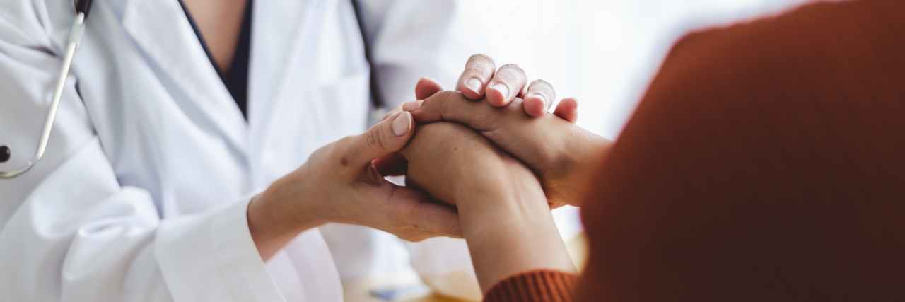 a doctor is holding a patient's hand