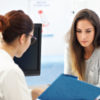 photo of woman talking to female doctor in office
