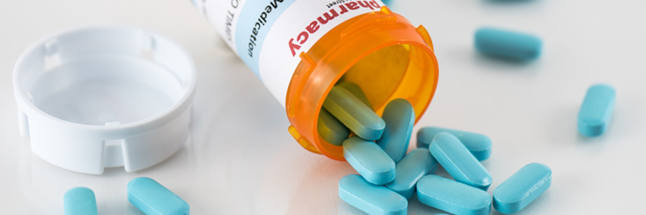 Prescription Bottle with Spilled Blue Pills