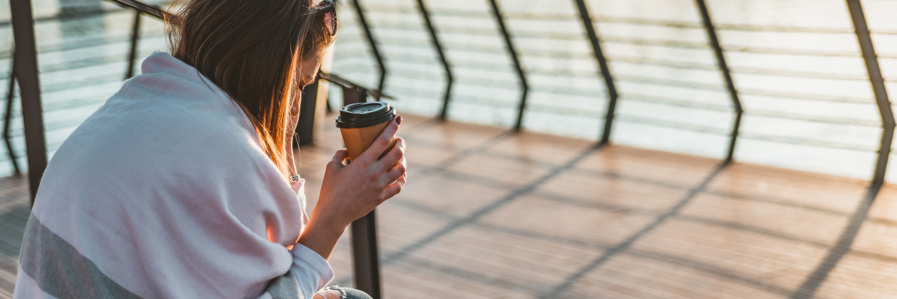 Living With Adrenal Insufficiency: Helpful Tips woman sitting with a cup of coffee near the water